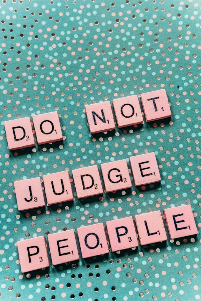 Scrabble tiles spelling 'Do Not Judge People' on a dotted background.